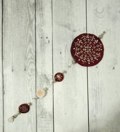 a red and white beaded necklace sitting on top of a wooden table