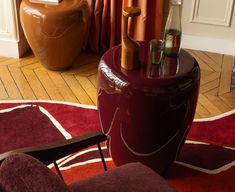 a red stool sitting on top of a wooden floor