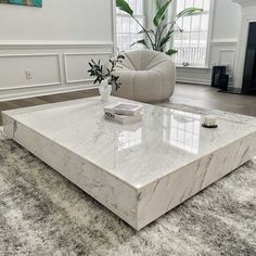 a white marble coffee table sitting on top of a carpeted floor in a living room