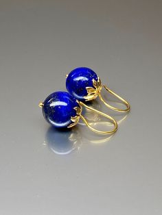 Beautiful vibrant and high-grade lapis lazuli globe earrings. The 12.5 mm lapis lazuli globes have a gorgeous deep vibrant royal blue color that shows celestial flecks of golden pyrite in the stone. The ultra-fine globes attached to a beautiful 14K gold-filled flower caps as they attached the vermeil on sterling ear wires. These are elegant and perfect earrings to go with any outfit. A pair of fine gemstone essentials. *Ball size (diameter): 12.5 mm *Metal: vermeil on sterling *Earrings drop len Royal Blue Lapis Lazuli Round Jewelry, Royal Blue Lapis Lazuli Jewelry, Royal Blue Round Lapis Lazuli Jewelry, Blue Polished Drop Earrings, Blue Drop Earrings With Polished Finish, Blue Lapis Lazuli Earrings For Formal Occasions, Elegant Lapis Lazuli Jewelry With Matching Earrings, Formal Blue Lapis Lazuli Earrings, Pierced Lapis Lazuli Round Jewelry