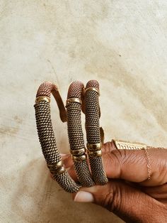 A beautifully handcrafted torque style brass cuff, accented with twisted brass, copper and lightly textured brass beads. Each bracelet is adjustable and can be adjusted to fix smaller or larger wrist. Handmade by African artisans in Kenya. DETAILS: Unisex Metal: Solid Brass & Copper Ships with polishing cloth for everlasting wear. Due to the handmade nature, expect slight imperfections. Each is one of a kind. *Packaged for gift giving. *Sold Individually (1 Bracelet). Not a set. Adjustable Wire Wrapped Bronze Cuff Bracelet, Antique Gold Adjustable Metal Bracelets, Adjustable Copper Braided Bohemian Bracelet, Adjustable Copper Bohemian Braided Bracelet, Adjustable Bohemian Copper Braided Bracelet, Adjustable Bronze Copper Bangle, Adjustable Hand Wrapped Bronze Cuff Bracelet, Adjustable Brass Beaded Bracelets, Adjustable Brown Copper Bangle