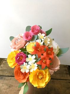 a vase filled with colorful flowers on top of a wooden table