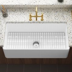 a white kitchen sink sitting under a faucet on top of a wooden counter