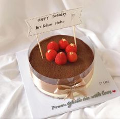 a chocolate cake with strawberries on top and a happy birthday sign in the middle