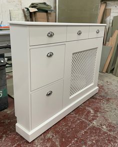 a white cabinet sitting on top of a red floor next to a pile of boxes