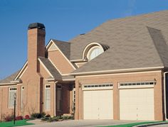 a large brick house with two garages on each side