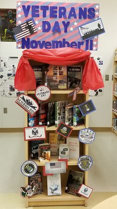 there is a book shelf with many books on it and a sign that says veterans day november 11