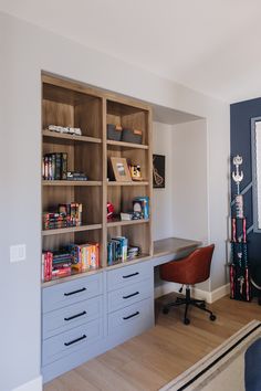 a room with a desk, bookshelf and other items on the shelves in it