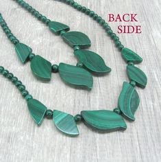 "Genuine Malachite gemstone beaded necklace, made of dark green stone beads in round and leaf shapes. Natural malachite jewelry, dainty bib necklace. Length: from 18 and 19 \" ( 46 and 48 cm ) - can be shortened on request. Beads: 4 mm balls and leaves measuring from 15 to 30 mm long. Please see all photos and select the style: Style 1 - the necklace with wider spread leaves, 19 inches long. Style 2 - the necklace with darker leaves placed closer together and making more V-shape, 18 inches long. Gift Jewelry With Dark Green Gemstone Beads, Dark Green Gemstone Beads Jewelry As Gift, Gift Dark Green Gemstone Beads Jewelry, Dark Green Gemstone Beads Jewelry Gift, Nature-inspired Jewelry With Round Gemstone Beads, Dark Green Gemstone Beads Jewelry For Gift, Hand-strung Green Nature-inspired Jewelry, Dark Green Beaded Jewelry With Round Beads, Handmade Elegant Malachite Beaded Necklaces