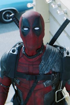 a deadpool character is standing in front of a wall with an arrow on it