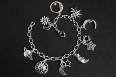 A collection of silver plated night sky themed charms have been dispersed around a shimmering silver plated bracelet chain in this handmade charm bracelet. This celestial charm bracelet is then completed with a lobster clasp and a 1/2 inch of chain at the end for adjustable sizing. Charms in this bracelet include a four sun charms, five moon charms, two star charms, and a Saturn charm. ● Sizing ● To determine your bracelet size, do a snug measurement of your wrist's circumference, then add 1/2 a Saturn Charm, Celestial Bracelet, Sun Bracelet, Stars Bracelet, Handmade Charm Bracelets, Moon Bracelet, Silver Plated Bracelet, Bracelet Chain, Star Bracelet