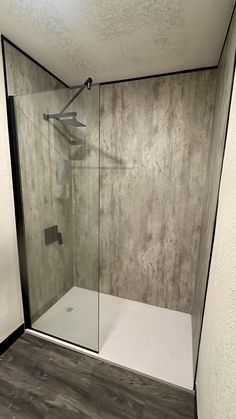 a walk in shower sitting inside of a bathroom next to a wall mounted shower head