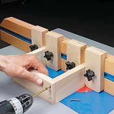 a person working with woodworking tools on a piece of blue paper next to a drill