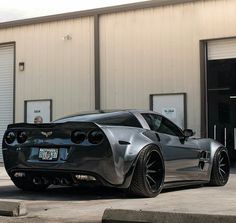 a silver sports car parked in front of a building