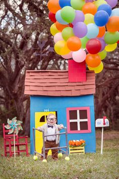 an old man standing in front of a house with balloons