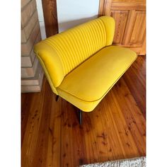 a yellow couch sitting on top of a wooden floor