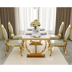 a dining room table with white chairs and gold trimmings on the top, in front of a window