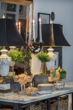 a table topped with lots of dishes and lamps