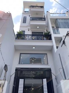 a tall white building with balconies and windows