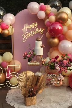 a table topped with lots of balloons and cake