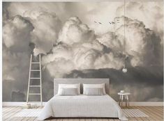 a bed sitting under a cloudy sky next to a ladder