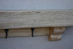 two hooks are attached to the side of a wooden wall