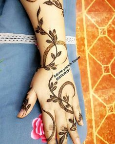 a woman's hand with henna tattoos on it