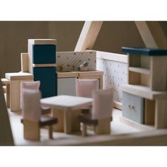 a doll house with furniture and accessories on the floor, including a small table and chairs