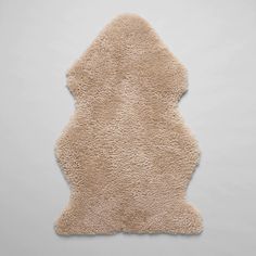 a beige sheepskin rug on a white background with room for text or image in the center