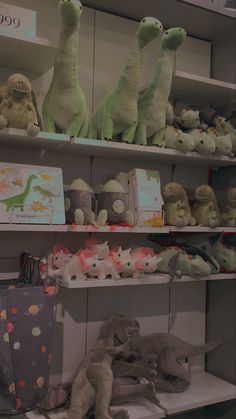 several stuffed animals are on shelves in a store