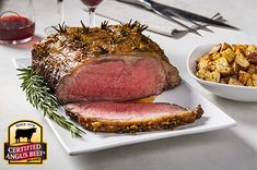 a steak and potatoes on a white plate with red wine in the glass next to it