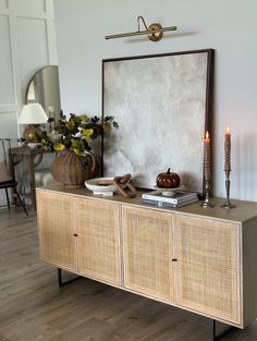 a table with some candles on it and a mirror in the corner next to it