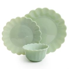 three green dishes are stacked on top of each other, one has a bowl in the middle