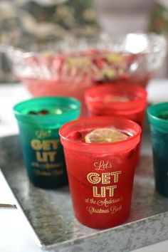 four cups are lined up on a tray, one is green and the other is red