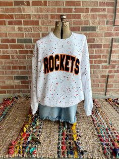 "Please Note: Current production time for new orders is 4 weeks before shipping.  This listing is for the above curved design with your Mascot name. This sweatshirt includes two paint splattered school or team colors  on a white sweatshirt, or color of your choice. The design is done in faux velvet with satin outline and gives it a rich feel! The velvet can be changed to sequins if desired. Just let us know in the personalization section.  How to order: Please copy and paste into Personalization College Cheer Shirts Designs, White Team Spirit T-shirt For Fall, College Fan Apparel Sublimation Design In White, White Collegiate Sublimation T-shirt For College, White Collegiate Sublimation Design T-shirt, Varsity Style White Sublimation Design Streetwear, Varsity Style White Sublimation Streetwear, Varsity Style White Sublimation Design For Game Day, White T-shirt For Game Day In Fall