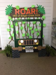 a decorated school bus sits in front of a wall with the word roar written on it