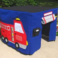 a blue fire truck storage bag sitting on top of a cement ground next to flowers