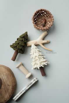 various wooden objects are arranged on a gray surface, including a basket and pine cones