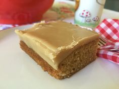 a piece of cake sitting on top of a white plate next to a red and white checkered napkin