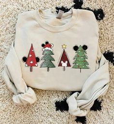 a mickey mouse christmas sweater with trees on the front and santa's hat on the back