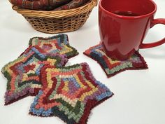 three crocheted coasters next to a red coffee cup and wicker basket