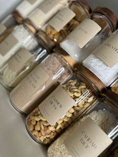 several jars filled with different types of nuts and seeds, all labeled with labels on them