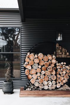 a large pile of logs sitting on top of a wooden table next to a window