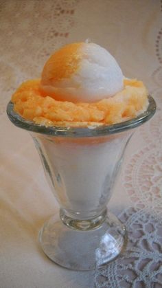 an ice cream sundae in a glass dish on a lace doily tablecloth