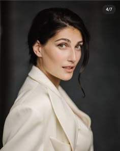 a woman in a white coat posing for a photo