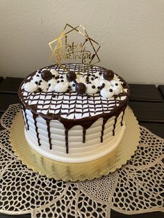 a birthday cake with white frosting and chocolate decorations