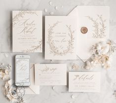 the wedding stationery is laid out on a marble table