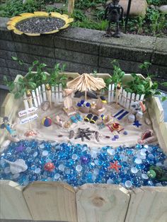 a sandbox filled with lots of different types of toys and decorations on top of it