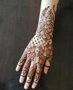 a woman's hand with henna tattoos on it