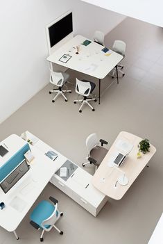 an overhead view of two office desks with computers on them and chairs around them